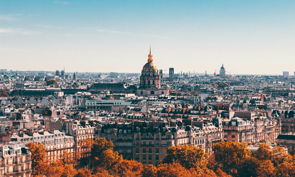 Panoramic view of Paris with the golden dome of Les Invalides in the foreground.