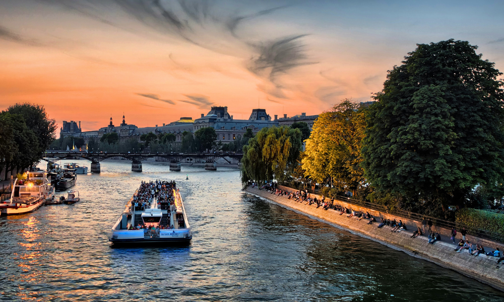 Seine River at sunset with a boat passing by in Paris.