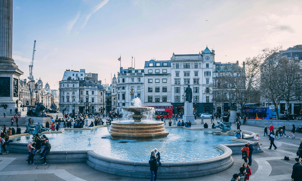 A view of Trafalgar Square in London. Showing surrounding historic buildings, and open public space.