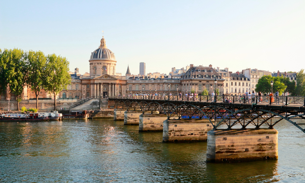 Pont des Arts in Paris seen from the banks of the Seine River toward the Institut de France.